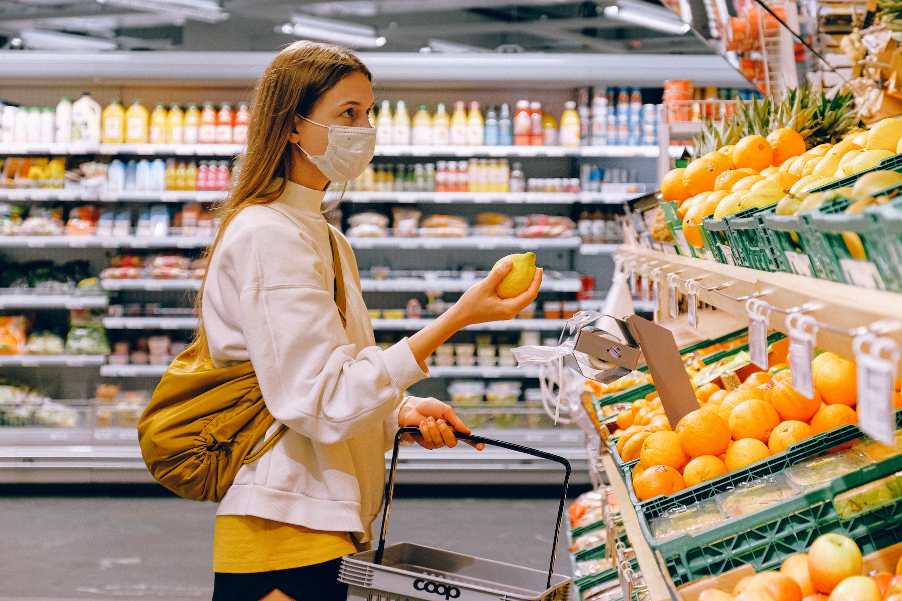 woman shopping at grocery store looking at the price